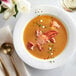 A bowl of soup with Boston Lobster Company claw and knuckle lobster meat with chives.