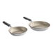 Two Vollrath Wear-Ever aluminum non-stick frying pans with black silicone handles.