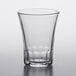 A Duralex clear glass tumbler on a white surface.