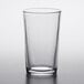 A clear Duralex glass tumbler on a white surface.