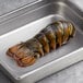 A Boston Lobster Company 12-14 oz. lobster tail in a metal pan.