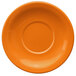 An orange stoneware saucer with a circle in the middle.