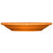 An orange International Tableware Cancun stoneware saucer on a white background.