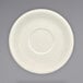 An ivory stoneware saucer with a circle in the middle.