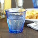 A close-up of a Duralex Picardie Marine glass filled with water on a table.