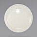 A close up of an International Tableware Valencia ivory stoneware plate with a rim.