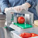 a tomato being sliced on a machine