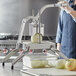 A woman using a Choice Prep onion slicer to cut a white onion.