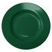 A close-up of a green stoneware pasta bowl with a circular center.