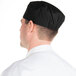 A man wearing a Chef Revival black mesh baker's hat.
