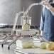 A woman using a Choice Prep onion slicer to cut a white onion.