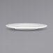 An International Tableware bright white porcelain plate with a small rim on a gray background.