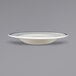 An ivory stoneware pasta bowl with blue bands on the rim.