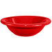 A close up of a red International Tableware stoneware grapefruit bowl.