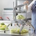 a person using a machine to cut cabbage