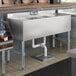 A Regency stainless steel underbar sink with two bowls and two drainboards.