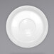 A white porcelain saucer with a circular design on a gray background.