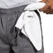 A person with a hand in their pocket holding a white towel.
