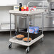A gray Metro plastic utility cart with food items on it.