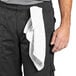 A man wearing Uncommon Chef black cargo chef pants with a white towel on his waist.
