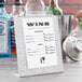 An Alumitique aluminum table tent with a swirl finish on a table with a menu.