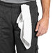 A man wearing Uncommon Chef black cargo chef pants with a white towel around his waist.