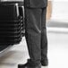 A person wearing Uncommon Chef black and white pinstripe pants.
