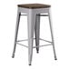 A Lancaster Table & Seating backless counter height stool with a walnut wood seat and metal legs.