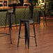 A Lancaster Table & Seating black metal restaurant barstool with black wood seat.