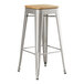 A Lancaster Table & Seating silver metal barstool with a wooden seat.