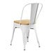 A Lancaster Table & Seating white metal cafe chair with a natural wood seat.