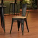 A Lancaster Table & Seating black metal chair with a natural wood seat and back.