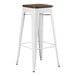 A white Lancaster Table & Seating backless barstool with a walnut wood seat.