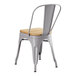 A Lancaster Table & Seating metal cafe chair with natural wood seat and back.