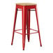 A red Lancaster Table & Seating backless bar stool with a natural wood seat.