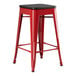 A Lancaster Table & Seating red metal backless counter height stool with black wood seat.