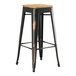 A Lancaster Table & Seating black metal barstool with a natural wood seat.