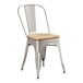 A Lancaster Table & Seating metal cafe chair with a natural wood seat.