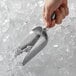 A hand using a Vollrath cast aluminum ice scoop to scoop ice.