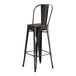 A Lancaster Table & Seating black metal barstool with a walnut wood seat.