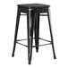 A Lancaster Table & Seating black metal backless counter height stool with a black wood seat.