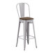 A white metal Lancaster Table & Seating cafe barstool with a walnut wood seat.