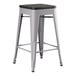 A Lancaster Table & Seating nickel gray metal backless counter height stool with a black seat.