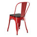 A Lancaster Table & Seating red metal cafe chair with black wood seat.