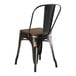 A black metal Lancaster Table & Seating restaurant chair with a walnut wood seat.