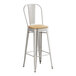 A Lancaster Table & Seating silver metal barstool with a natural wood seat.