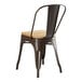 A brown metal Lancaster Table & Seating cafe chair with a natural wood seat.