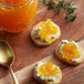 A piece of bread with Dalmatia tangerine spread on top on a table.