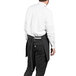 A man wearing a black and white pinstripe tuxedo apron.