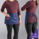 A woman wearing a navy blue Uncommon Chef waist apron.